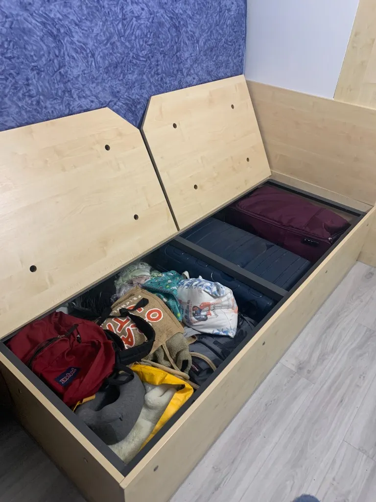 Bags and suitcases stored under a wooden bench